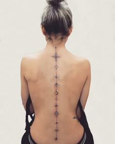 the back of a woman's neck with tattoos on it