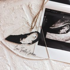 an ornament hanging from a string on top of a white tablecloth next to a photo