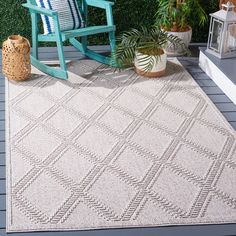 an outdoor area rug with a rocking chair and potted plants