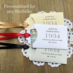 three personalized birthday cards on top of a doily with red, white and black ribbons