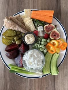 a white plate topped with different types of vegetables and dips on top of it