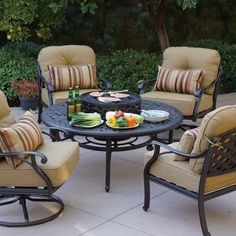 an outdoor table with four chairs around it and a plate of food on the table