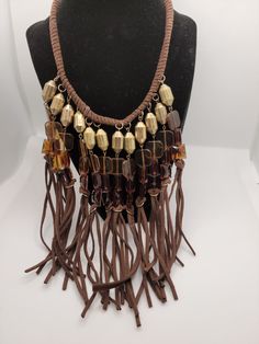 Vintage Brown Faux Suede Fringe Collar Statement 20-inch Necklace with 3-inch extender. This BoHo style necklace is suitable for any occasion and is light weight and comfortable to wear. Features brass colored metal and brown colored glass beads. This vintage treasure has been previously loved and worn and with any vintage item there might be slight imperfections, blemishes or inconsistencies. I would love to see you wearing your new necklace, please tag me on FB @Parididdles or on Instagram and if you're happy with your purchase please don't forget to write a review! Thank you for taking the time to visit my shop! Elegant Brown Metal Beaded Necklace, Brown Metal Necklace For Party, Brown Costume Jewelry Necklace For Party, Brown Adjustable Costume Jewelry, Adjustable Brown Costume Jewelry, Brown Adjustable Long Necklace, Brown Dangling Beads Jewelry For Gift, Brown Metal Beaded Necklaces As Gifts, Brown Metal Dangle Necklaces