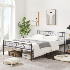 a bedroom with white walls and flooring has a metal bed frame in the middle