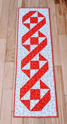 a red and white table runner on wooden floors