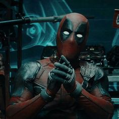 deadpool is holding his hand up to the camera