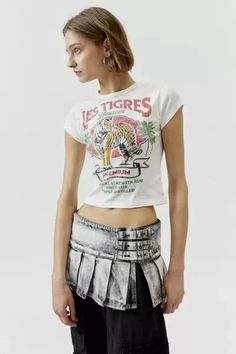 Baby tee with a Les Tigres printed at the front. Hits at the waist in a cropped silhouette with a crew neckline and cap sleeves. Find it exclusively at Urban Outfitters. Features: - Les Tigres graphic baby tee - Tee with a Les Tigres graphic at the front - Cropped silhouette - Crew neckline - UO exclusive Content + Care: - 100% Cotton - Machine wash - Imported Size + Fit: - Model in White is 5’10' and wearing size Small - Measurements taken from size Small - Chest: 24' - Length: 17' Fitted Cropped T-shirt With Logo Print, Fitted Cotton Cropped T-shirt With Graphic Print, Retro Cropped T-shirt With Text Print For Summer, Fitted Logo Print Cropped T-shirt For Summer, Urban Outfitters Letter Print T-shirt For Summer, Fitted Cropped T-shirt With Logo Print And Crew Neck, Fitted Crew Neck Cropped T-shirt With Logo, Graphic Tee Crop Top With Crew Neck, Relaxed Fit Graphic Tee Crop Top With Crew Neck