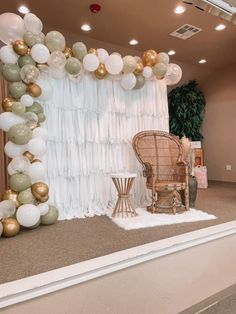 a chair sitting in front of a backdrop with balloons