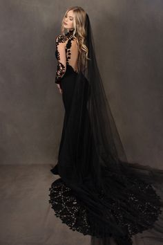 a woman wearing a long black dress and veil