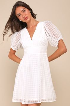 Let your adorable style and the Lulus Cultivated Cuteness White Burnout Gingham Tie-Back Mini Dress pave the way to an unforgettable summer! Lightweight woven organza boasts a burnout gingham pattern as it shapes short puff sleeves with elastic and ruffles at the cuffs. Fitted bodice has a V-neckline and chic pleated details, atop a banded waist with matching pleated accents. Turn around to reveal a flirty open back with a tie at the top. Flaring skirt finishes at a mini hem. Smocked panel and h White V-neck Dress For Picnic, Gingham V-neck Mini Dress For Picnic, Fitted V-neck Plaid Dress For Spring, Spring Puff Sleeve Mini Dress For Picnic, Spring Picnic Dresses With Puff Sleeves, Spring Picnic Puff Sleeve Dresses, Feminine Gingham Dress For Day Out, Feminine Summer Mini Dress For Picnic, Feminine Plaid Spring Dress