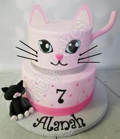 a pink cake with a cat on top and the number seven written in large letters