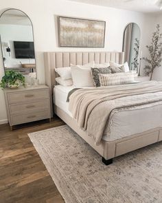 a bedroom with a bed, dressers and mirror in it's center area