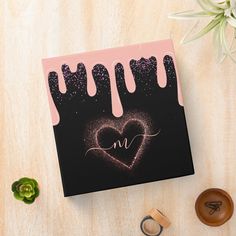 a pink and black greeting card with the word love written on it, surrounded by other items