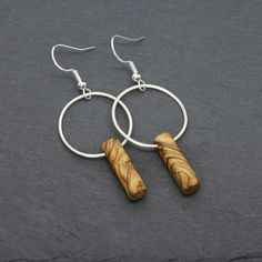 Handmade solid olive wood earrings with a satin Argentium silver ring and silver ear wire hooks. The olive wood used to craft these earrings comes directly from olive cultivation in the Holy Land and is coated with olive oil only to maintain its natural warmth. Thanks to its beautiful streaks and shades, the olive wood gives to each earrings pair a unique and personal aspect. The soldered Argentium silver ring has a satin finish and adds a touch of elegant shine thanks to its white gold-like col Wood Jewellery Handmade, Wood Jewelry Diy, Wooden Wedding Bands, Stainless Steel Wedding Ring, Silver Bead Earrings, Wood Wedding Band, Wooden Jewellery, Nugget Necklace, The Holy Land