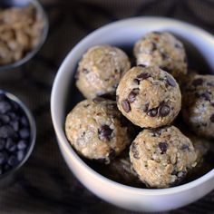 a white bowl filled with cookies and raisins next to bowls of chocolate chips