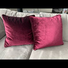 two pillows sitting on top of a couch