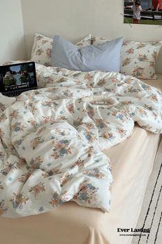 an unmade bed with a laptop on it