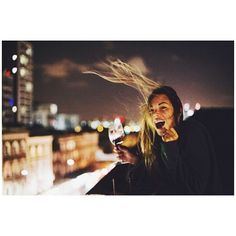 a man with long hair holding a glass of wine