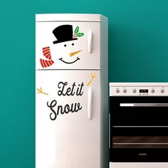 a white refrigerator freezer sitting next to an oven with a snowman sticker on it