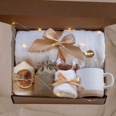 an open box with two mugs and other items in it that are wrapped in twine