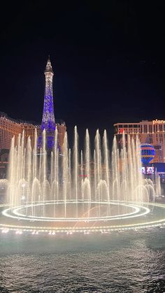 the fountains in front of the eiffel tower are lit up with blue lights