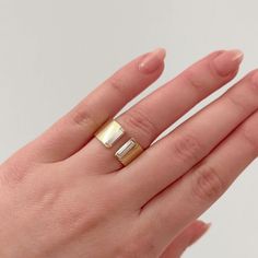 a woman's hand with a gold and silver ring on top of her finger