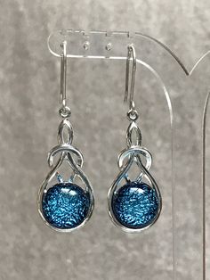 A stunning pair of large tear shaped drop earrings with a superior silver plated setting and a vibrant sky  blue dichroic fused glass stones. This glass has has lovely paler frosty blue highlights and a crackled pattern. The earrings can have handcrafted sterling silver 925, hypoallergenic surgical steel or silver plated clip-on ear fittings. The complete length of drop is 45mm and 15mm at their widest point.  They are supplied in a presentation/gift box.  The stones have been made individually Elegant Turquoise Drop Teardrop Earrings, Sterling Silver Long Drop Teardrop Earrings For Party, Elegant Blue Teardrop Pendant Earrings, Blue Elegant Teardrop Pendant Earrings, Elegant Turquoise Teardrop Earrings As Gift, Blue Elegant Teardrop Earrings, Blue Pear-shaped Teardrop Earrings For Anniversary, Elegant Blue Teardrop Earrings, Blue Dangle Teardrop Earrings For Anniversary