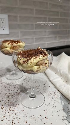 two desserts sitting on top of a counter next to each other in wine glasses