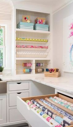 a kitchen with lots of crafting supplies on the counter and drawers in front of it