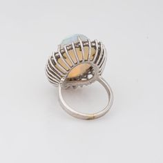 Stylish vintage natural opal ring (circa 1970s to 1980s) crafted in 14 karat white gold.   Natural opal measures 22mm x 14.5mm (estimated at 22 carats). The opal is in very good condition and free of cracks or crisps. Round brilliant cut diamonds total an estimated 1.40 carats (estimated at H-I colour and VS2-SI1 clarity).   The opal is full of colour and fire (opals are difficult to photograph and the true colours of the opal does not show in the pictures). The colour matrix is vivid from merma Cocktail Jewellery, Opal Ring Vintage, Natural Opal Ring, Cocktail Jewelry, Bold Jewelry, Opal Ring, Natural Opal, Ring Vintage, Round Brilliant Cut Diamond