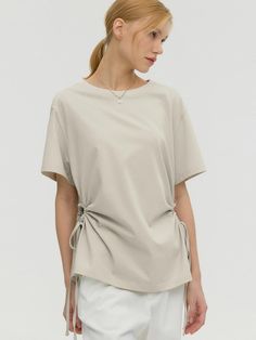 This is MONGDOL’s short-sleeved t-shirt featuring side hole string details, adding a unique touch to the design. The strings on the side holes allow for various attractive styles. The natural shirring of the side cut-out holes creates a slim waistline. With its relaxed fit and basic round neck design, it offers comfortable and effortless wear. It can be worn alone or layered, making it versatile for different looks. This short-sleeved t-shirt exudes a stylish and refreshing mood. Overall, it combines an oversized silhouette with cut-out details to add a touch of femininity. Its versatility is enhanced by the cut-out details, making it highly adaptable for various styling options.- Ideal for daily wear- Can be paired with different bottoms to create various looks- Basic design that ma Summer Tops With Drawstring Tie And Short Sleeves, Summer Short Sleeve Tops With Drawstring Tie, Summer Tops With Short Sleeves And Drawstring Tie, Round Neck Design, Basic Design, Side Cuts, Oversized Silhouette, Neck Designs, Daily Wear