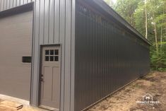 a large metal building sitting in the middle of a forest