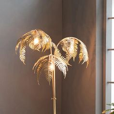 a lamp that is on top of a table next to a potted plant in front of a window