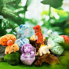 a group of stuffed animals sitting on top of a green field next to rocks and plants