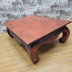 a wooden coffee table sitting on top of a hard wood floor next to a wall