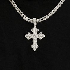 Introducing the Iced Gothic Cross in White Gold - a bold addition to your pendant collection. Crafted with a durable 14k White Gold finish and hand-set stones, this cross is guaranteed to make a statement! Pair this piece with our 5mm Tennis Chain in White Gold for a complete, elevated look. This product is guaranteed for life - GLD will repair the item should you experience any defects in craftsmanship or breakage. Specifications - 35mm x 42mm (Width x Height) - Bail: Fits up to 5mm Tennis Chai Silver Diamond Cross Pendant Jewelry, Silver Iced Out Cross Pendant Necklace, White Gold Necklace With Large Cross Pendant, Elegant Iced Out Cross Pendant Jewelry, White Iced Out Cross Jewelry, Silver Cross Diamond Jewelry, Silver Diamond Cross Jewelry, White Gold Large Cross Pendant Jewelry, Iced Out White Gold Cross Pendant Jewelry