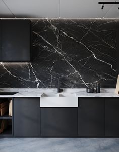 a black and white kitchen with marble counter tops, cabinets and drawers on the wall