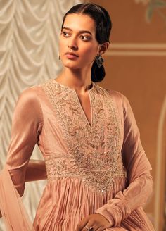 Elevate your elegance with this dusky pink long anarkali, crafted from luxurious fine silk. Adorned with intricate embroidery, its flowing silhouette offers grace and sophistication. Complemented by a matching net dupatta, also embellished with delicate embroidery, this ensemble is perfect for any special occasion, blending timeless beauty with modern charm. Pink Churidar, Churidar Sleeves, Ridhi Mehra, Pink Anarkali, Silk Anarkali, Long Anarkali, Embroidered Crop Tops, Delicate Embroidery, Dusky Pink