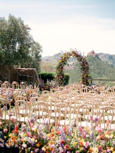 an outdoor ceremony setup with chairs and flowers