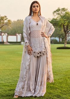 Ivory kurta with thread, sequin, pearl, bead embroidery in floral pattern. Paired with pleated embroidered sharara & scallop border embroidered dupatta. Anarkali Sets With Pearl Embroidery In Cream, Cream Sets With Pearl Embroidery For Eid, Anarkali Cream Sharara With Pearl Embroidery, Festive Cream Sharara With Pearl Embroidery, Festive Cream Anarkali Set With Pearl Embroidery, Cream Sharara With Pearl Embroidery For Eid, Bollywood Style Sharara With Pearl Embroidery And Traditional Drape, Bollywood Style Sharara With Pearl Embroidery, Designer Sharara With Pearl Embroidery And Traditional Drape