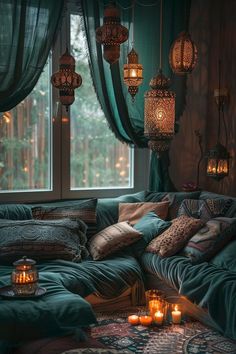 a living room filled with lots of pillows and candles in front of a large window