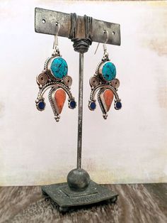 These Turquoise and Coral earrings with a pop of Lapis Lauzli are a beautiful blend of traditional Tibetan and Nepalese design with a modern twist. The unique shape, intricate metal work and vibrant colors of the coral, turquoise, and lapis stones make these earrings a statement piece that will add a unique and cultural touch to your style. Handcrafted by skilled artisans, using traditional techniques passed down through generations, these earrings are a true work of art.- Made with genuine cora Turquoise And Coral, Coral Earrings, Metal Work, Coral Turquoise, 925 Sterling Silver Earrings, Traditional Techniques, Metal Working, Sterling Silver Earrings, Silver Earrings