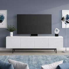 a living room with blue walls and white furniture in front of a flat screen tv