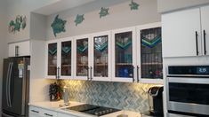 a kitchen with white cabinets and stainless steel appliances