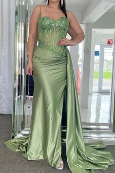 a woman in a green dress posing for the camera