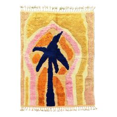 an orange and pink rug with a palm tree on the front, against a white background