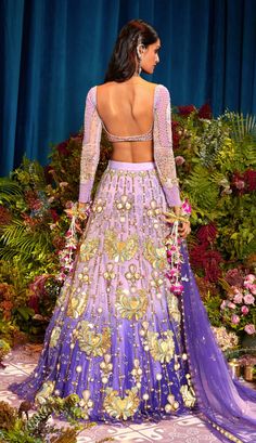 Step into a world of enchantment with our shaded lilac tulle lehenga set - a spellbinding fusion of colors and textures. Watch as custom cut acrylic pieces, gold metal embellishments, and rich fabric appliques come together to create a truly mesmerizing design. Paired with our signature butterfly full-sleeved blouse in lilac silks, and a delicately embroidered tulle dupatta that glistens with metals, pearls, and sequins. Get ready to dazzle and make a statement on your special day! Lilac Lehngas, Luxury Embellished Purple Lehenga, Luxury Purple Floral Embroidered Lehenga, Purple Embellished Organza Choli, Embellished Purple Choli, Ombre Lehenga, Tulle Lehenga, Tangled Aesthetic, Lilac Blouse