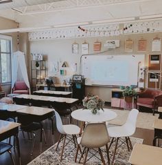 an empty classroom with desks, chairs and a projector screen in the corner