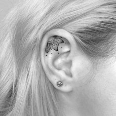 a woman's ear with a butterfly tattoo on it