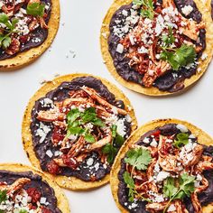 several tortillas topped with meat and garnished with cilantro sauce